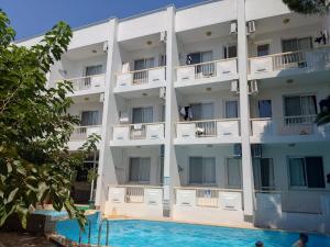 an apartment building with a swimming pool in front of it at Palmiye Hotel in Özdere