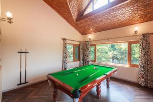 a pool table in a room with a window at StayVista at Pinewood Villa with Pool Table in Srinagar