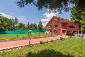 a house with a garden in front of it at StayVista at Pinewood Villa with Pool Table in Srinagar