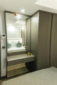 a bathroom with a mirror and a bed in it at Leaf River Suites in Antalya