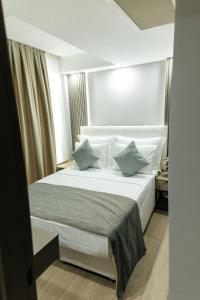 a bedroom with a bed with white sheets and pillows at Leaf River Suites in Antalya