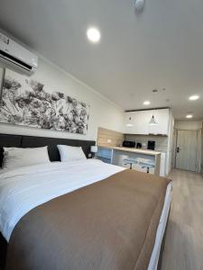 1 dormitorio con 1 cama grande y cocina en Apart Astana en Taldykolʼ