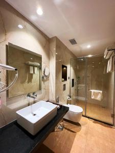 a bathroom with a sink and a toilet and a shower at Sachika Hotels, Guwahati in Guwahati