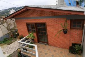 una pequeña casa de ladrillo rojo con puerta blanca en Loft bem equipado com WiFi em Bento Goncalves RS, en Bento Gonçalves