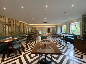 a dining room with tables and chairs in a restaurant at Sachika Hotels Guwahati- Pure Veg in Guwahati