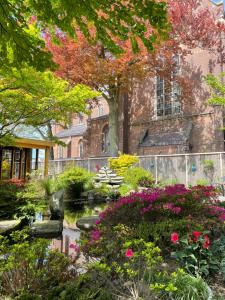 a garden in front of a building with flowers at B&B de wetenschap (der gastvrijheid) 