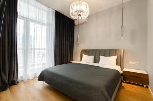 a bedroom with a large bed and a chandelier at 19267 Residential complex Central Park cozy apartment in Kyiv