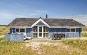 a blue house with a table and chairs in front of it at Gorgeous Home In Hvide Sande With Sauna in Havrvig