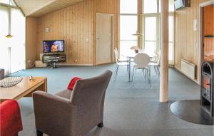 a living room with a table and chairs and a television at Gorgeous Home In Hvide Sande With Sauna in Havrvig