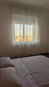 - une chambre avec un grand lit et une fenêtre dans l'établissement La Terrazza del Re, à Verceil
