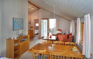 ヴィデ・サンデにあるAwesome Home In Hvide Sande With Kitchenのキッチン、ダイニングルーム(木製のテーブルと椅子付)