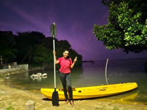 卡佩蹄尤的住宿－Kalpitiya Chalets by Thilanka，站在水中划桨船的女人