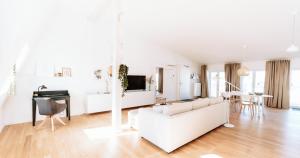 a white living room with a white couch and a table at Deichstadt Apartments in Neuwied