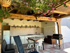 a patio with a table and chairs and a kitchen at VILLA ENA in Torre dell'Orso