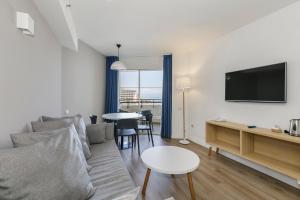 a living room with a couch and a tv and a table at Sol Timor Apartamentos in Torremolinos
