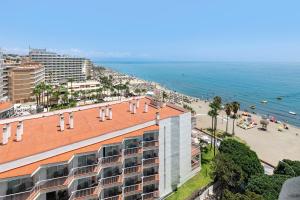 a view of a beach with a building and the ocean at Sol Puerto Marina in Torremolinos