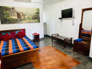 a room with a bed and a flat screen tv at Hotel 100 in Dehiwala