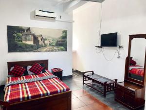 a bedroom with a bed and a tv on the wall at Hotel 100 in Dehiwala