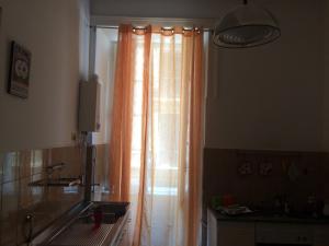 ナポリにあるO サラチノ B＆​​Bのキッチン(窓、オレンジ色のカーテン付)