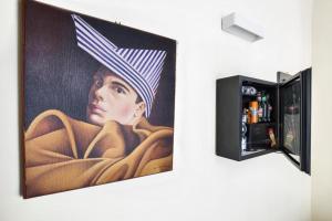 a painting of a woman with a hat on a wall at Boutique Hotel Piazza Carità in Naples