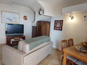 a living room with a couch and a tv at Neve Nof in Rosh Pinna