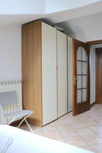 a room with a bed and a chair and cabinets at Lovely Apartment near Canal - Via Foscolo in Corsico