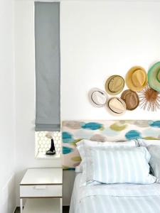 een slaapkamer met een bed met hoeden aan de muur bij Attico unico ed incantevole in Lido Conchiglia