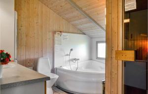 uma casa de banho com uma banheira branca e um WC. em Nice Home In Hvide Sande With Wifi em Bjerregård