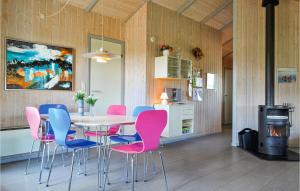 BjerregårdにあるNice Home In Hvide Sande With Wifiのダイニングルーム(テーブル、ピンクとブルーの椅子付)