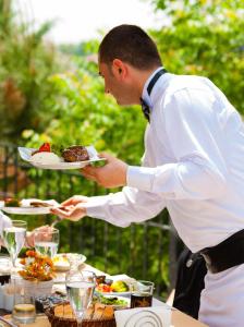 a man holding a plate of food on a table at İstanbul Bosphorus Hotel Symbola in Istanbul