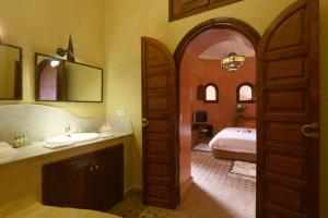 a bathroom with a sink and a bed in a room at Riad L'Emir in Marrakech