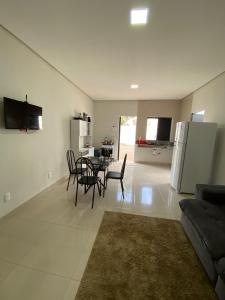 uma sala de estar com mesa e cadeiras e uma cozinha em Flat Dona D - Prox da JK em Palmas