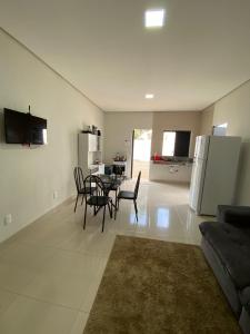 a living room with a table and chairs and a kitchen at Flat 03 - Prox da JK - Delior 2 in Palmas +10 photos