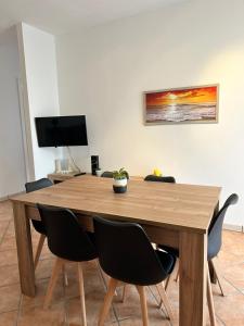 a wooden dining room table with chairs and a television at VILLA ENA in Torre dell'Orso