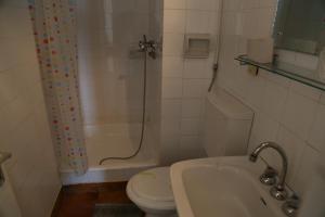 a bathroom with a toilet and a shower and a sink at Hotel National in Mamaia