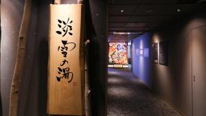 a hallway with a wall with writing on it at Dormy Inn Aomori Natural Hot Spring in Aomori