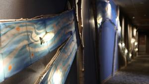 a hallway with a blue wall with a bird on it at Dormy Inn Aomori Natural Hot Spring in Aomori