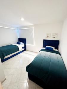 1 Schlafzimmer mit 2 Betten in einem Zimmer in der Unterkunft Lujoso apartamento frente a la playa in Cartagena de Indias