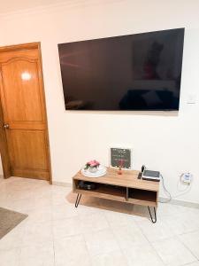 ein Wohnzimmer mit einem Tisch und einem Flachbild-TV in der Unterkunft Lujoso apartamento frente a la playa in Cartagena de Indias