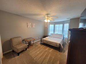 1 dormitorio con 1 cama, 1 silla y ventilador de techo en The Relaxation Getaway en Savannah
