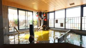 a pool of water in a building with people in it at Dormy Inn Aomori Natural Hot Spring in Aomori