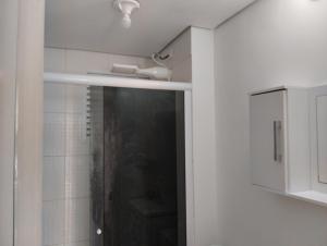 um chuveiro com uma porta de vidro na casa de banho em Alcimar Zuzo em Mogi das Cruzes