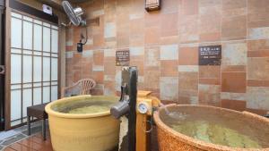 a bath tub in a room with a large bucket at Dormy Inn Aomori Natural Hot Spring in Aomori