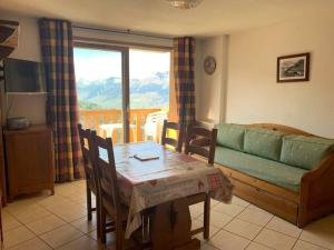 una sala de estar con una mesa y un sofá en Paradiski proche des pistes plan peisey, en Peisey-Nancroix