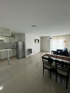a living room with a table and chairs and a kitchen at Departamento Skala in Cordoba