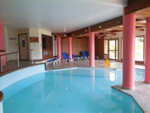 una gran piscina en un edificio con sillas azules en Paradiski proche des pistes plan peisey, en Peisey-Nancroix