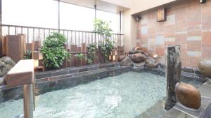 a swimming pool in the middle of a building at Dormy Inn Aomori Natural Hot Spring in Aomori