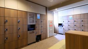 a row of lockers in a locker room with a counter at Dormy Inn Aomori Natural Hot Spring in Aomori