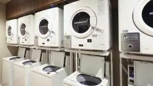 a row of washers and dryers are lined up at Dormy Inn Aomori Natural Hot Spring in Aomori