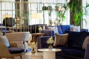 a living room with a blue couch and chairs and tables at Grand Hotel Brioni Pula, A Radisson Collection Hotel in Pula